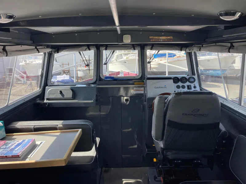 Slide: The Image of Interior of a 2018 Duckworth 28 Offshore boat with seating and control panel. - 46