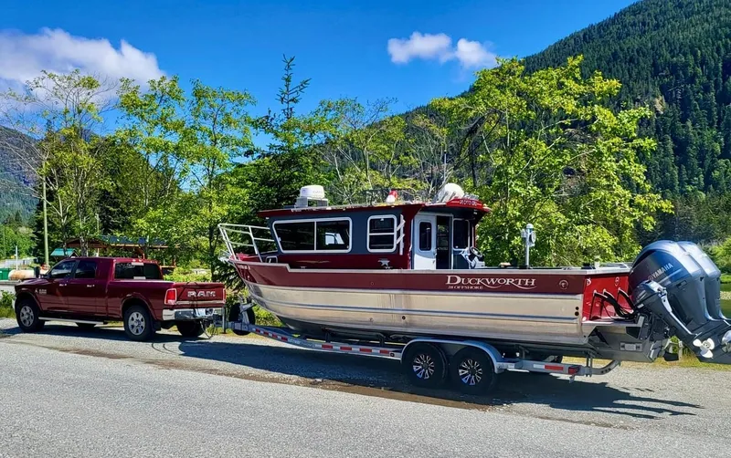 Slide: The Image of 2018 Duckworth 28 Offshore boat on trailer, towed by a red Ram truck, scenic mountain backdrop. - 7
