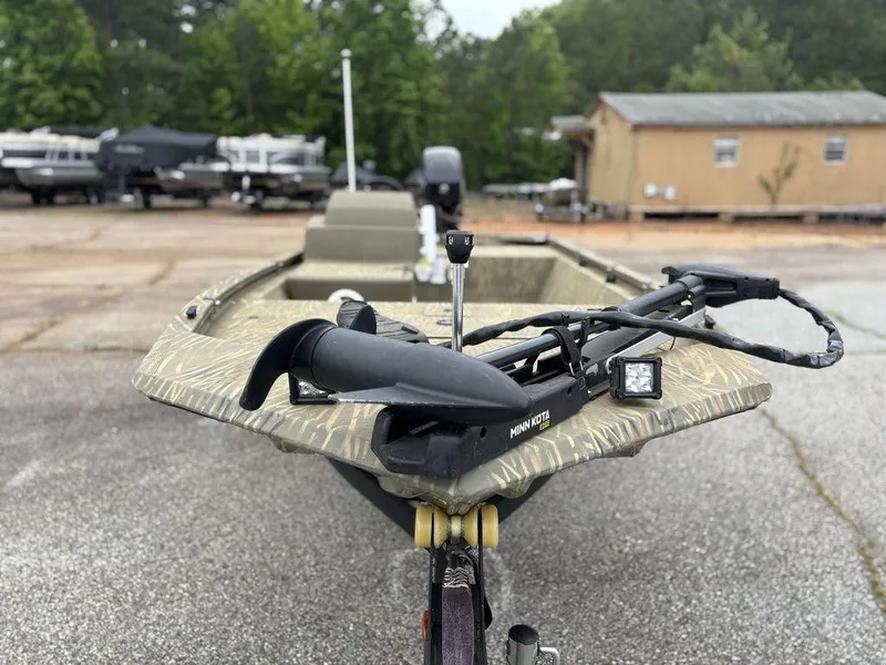 Slide: The Image of 2020 Tracker GRIZZLY® 1648 SC boat with camouflage design, parked outdoors. - 6