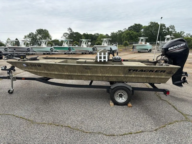 Slide: The Image of 2020 Tracker GRIZZLY® 1648 SC boat on trailer, parked outdoors with Mercury outboard motor. - 8