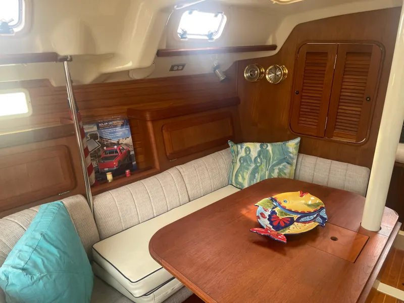 Slide: The Image of 1992 Hunter Legend 375 sailboat interior with cozy seating and decorative pillows. - 6