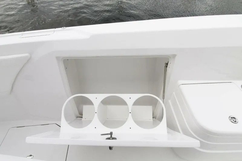 Slide: The Image of 2024 Intrepid 375 Nomad SE boat storage compartment with cup holders, open on deck. - 19