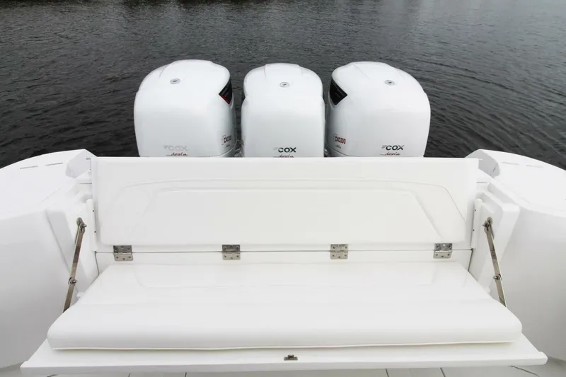 Slide: The Image of 2024 Intrepid 375 Nomad SE with triple outboard engines on a calm water backdrop. - 3