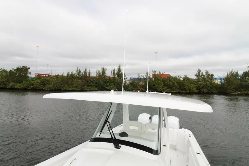 Slide: The Image of 2024 Intrepid 375 Nomad SE boat on calm water, featuring sleek design and spacious deck. - 4