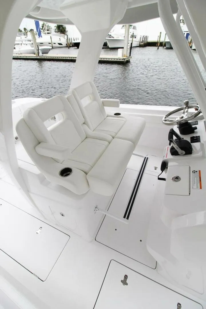 Slide: The Image of 2024 Intrepid 375 Nomad SE boat interior with white seating and steering console. - 5
