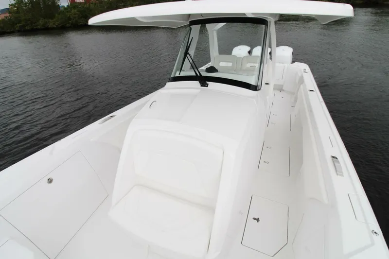 Slide: The Image of 2024 Intrepid 375 Nomad SE boat on water, showcasing sleek white design and spacious deck. - 6