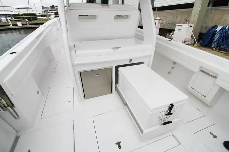 Slide: The Image of 2024 Intrepid 375 Nomad SE boat interior with storage compartments and seating. - 9