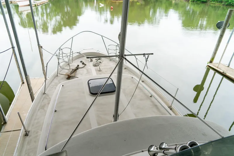 Slide: The Image of 1979 Mainship 34 boat docked on calm water, viewed from the deck. - 12