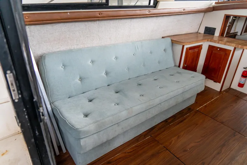 Slide: The Image of 1979 Mainship 34 interior with light blue sofa and wooden cabinetry. - 14