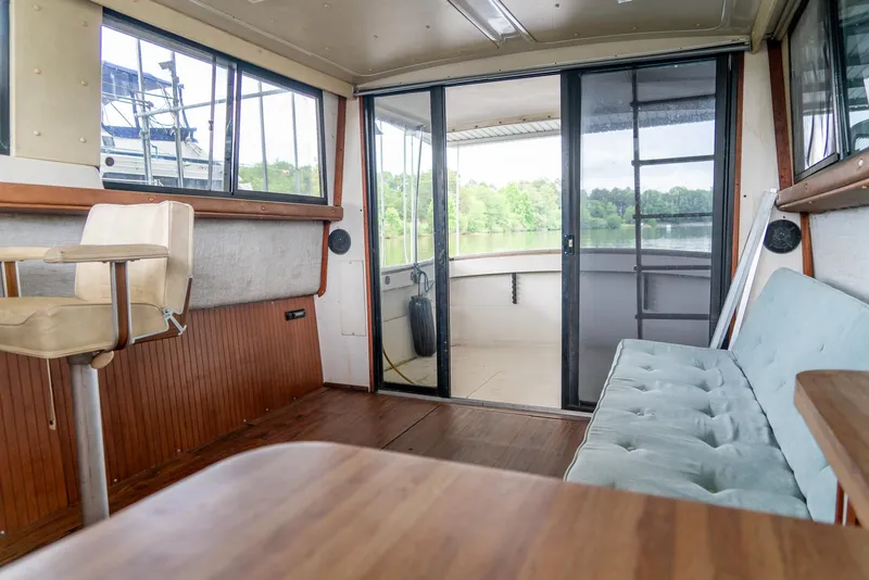 Slide: The Image of Interior of a 1979 Mainship 34 boat with seating and sliding glass doors. - 16