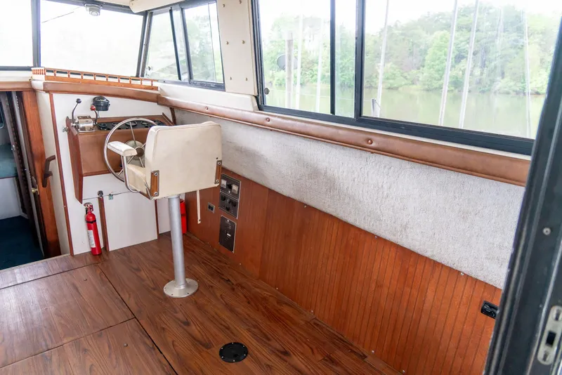 Slide: The Image of 1979 Mainship 34 boat interior with wooden flooring and steering wheel. - 17