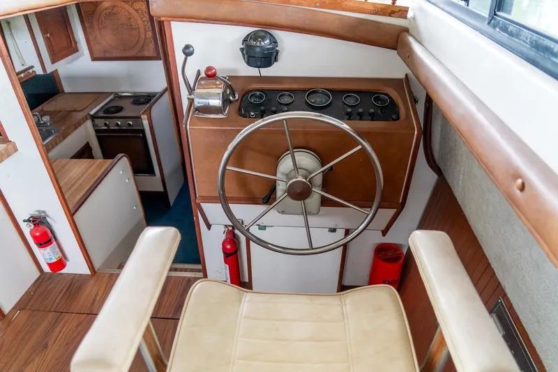 Slide: The Image of 1979 Mainship 34 boat interior with steering wheel, gauges, and kitchen area. - 19