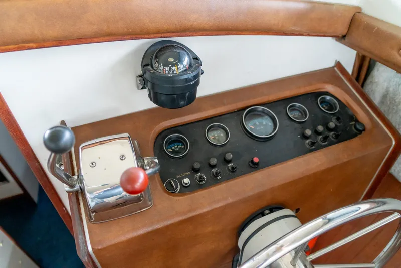 Slide: The Image of 1979 Mainship 34 helm with compass, gauges, and steering wheel. - 20