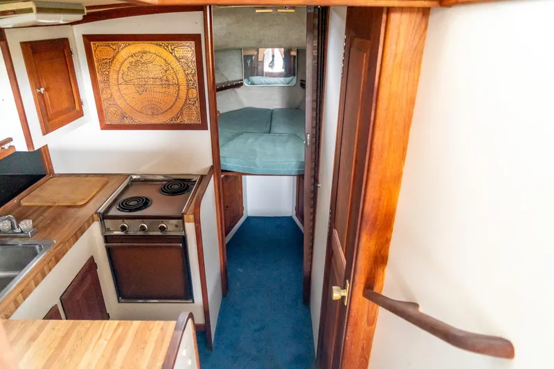 Slide: The Image of 1979 Mainship 34 interior with kitchen, stove, and cozy sleeping area. - 27