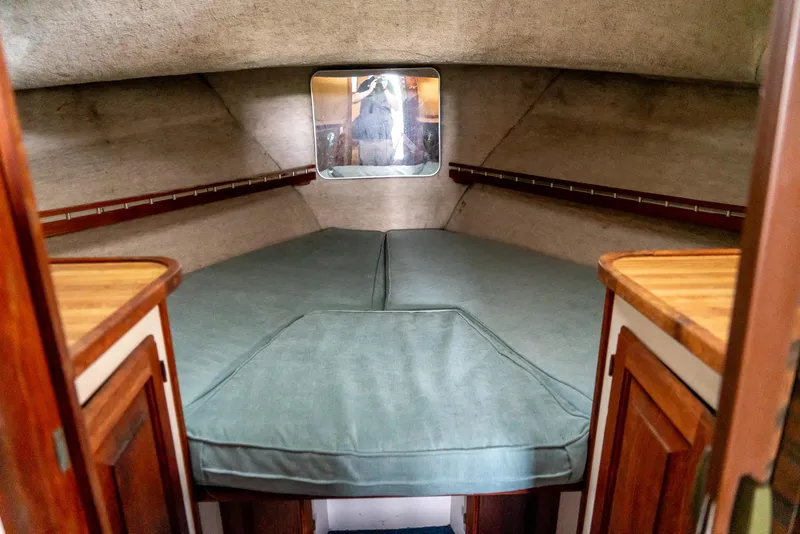 Slide: The Image of 1979 Mainship 34 cabin interior with cozy bed and wooden accents. - 28