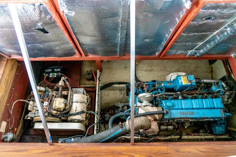 Slide: The Image of Engine compartment of a 1979 Mainship 34 boat, showcasing dual engines and insulation. - 29