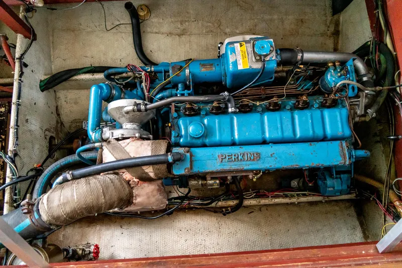 Slide: The Image of 1979 Mainship 34 engine compartment with Perkins marine engine, showcasing detailed components and wiring. - 30