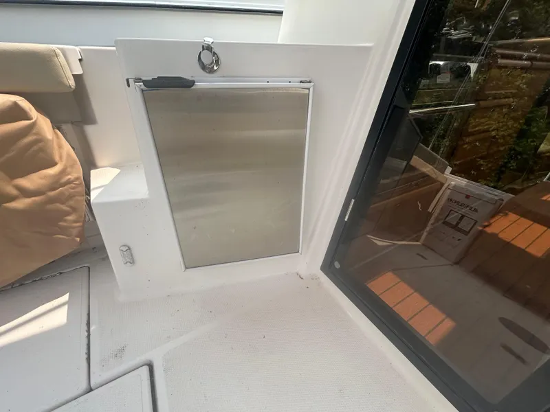 Slide: The Image of 2021 Ranger Tugs R-27 interior with stainless steel door and seating area. - 4