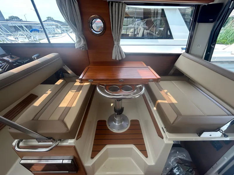 Slide: The Image of Interior of 2021 Ranger Tugs R-27 with seating and wooden table. - 6