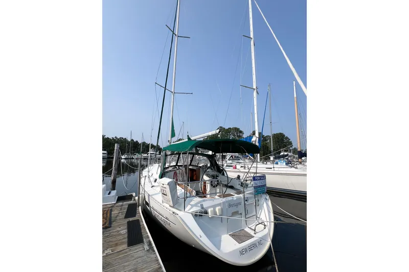 The Image of 2002 Beneteau 361 sailboat docked, featuring green canopy and "For Sale" sign. - 0