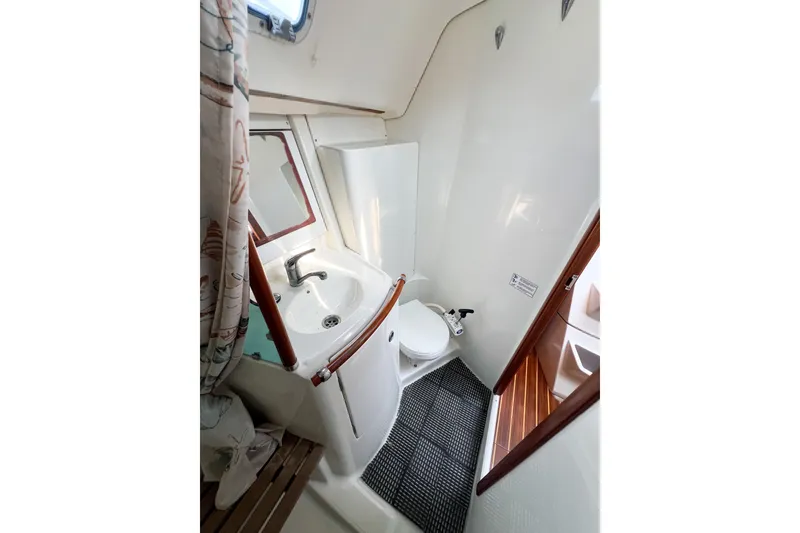Slide: The Image of Bathroom interior of 2002 Beneteau 361 yacht, featuring sink, toilet, and shower area. - 11