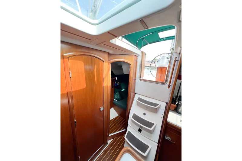Slide: The Image of Interior view of 2002 Beneteau 361 sailboat, featuring wooden cabinetry and steps to deck. - 15