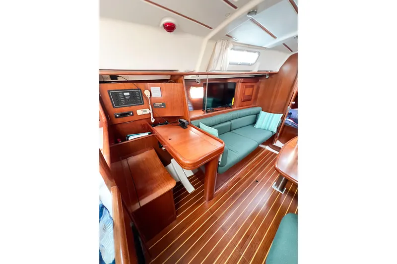 Slide: The Image of Interior of 2002 Beneteau 361 yacht with wooden finish and green seating. - 16