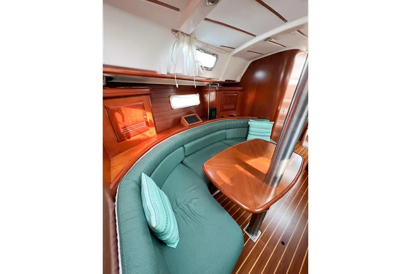 Slide: The Image of Interior of 2002 Beneteau 361 yacht with elegant wood finish and green seating. - 17