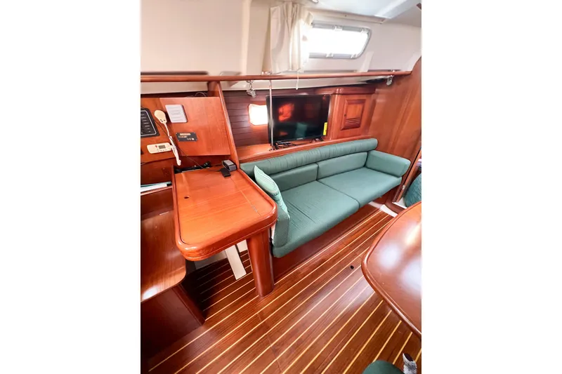 Slide: The Image of Interior of 2002 Beneteau 361 yacht with green sofa and wooden furnishings. - 21