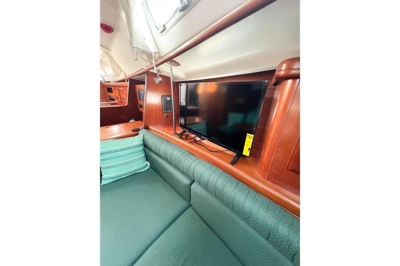 Slide: The Image of Interior of 2002 Beneteau 361 yacht with green seating and mounted TV. - 25