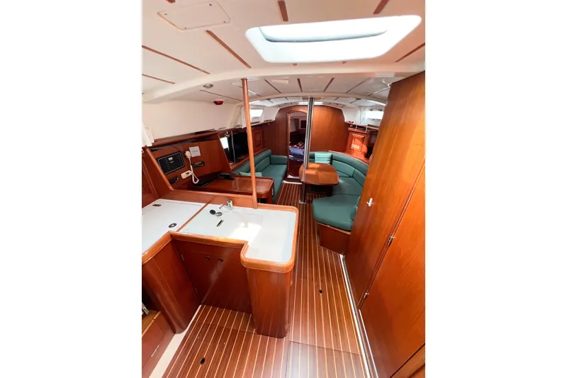 Slide: The Image of Interior of 2002 Beneteau 361 sailboat with wood finish and green seating. - 31
