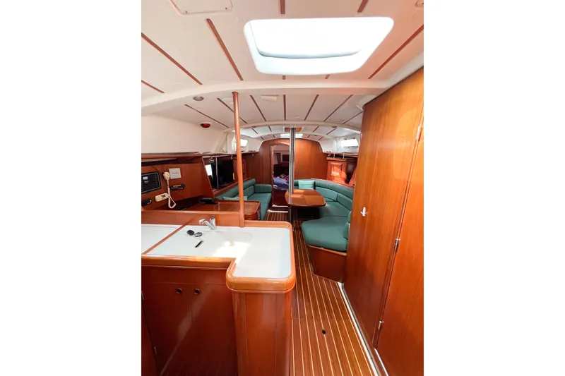 Slide: The Image of Interior of 2002 Beneteau 361 sailboat with wood finish and green seating. - 32
