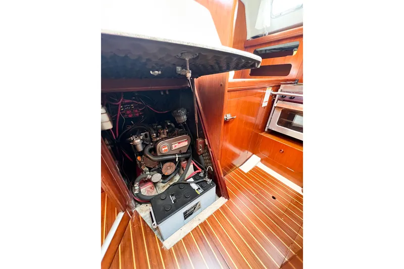 Slide: The Image of Engine compartment of a 2002 Beneteau 361 sailboat, showcasing the engine and interior wood finish. - 34