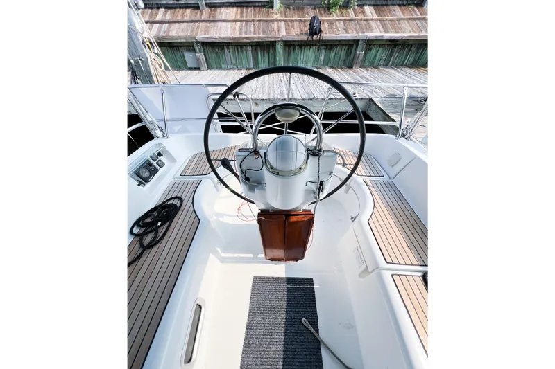 Slide: The Image of 2002 Beneteau 361 sailboat cockpit with steering wheel and wooden deck details. - 5