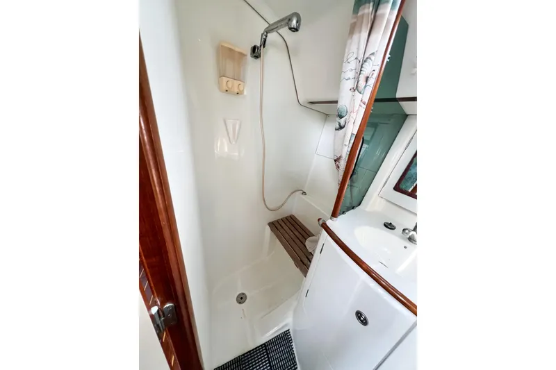 Slide: The Image of Beneteau 361 2002 yacht bathroom with shower, sink, and wooden accents. - 9
