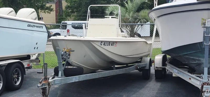 Slide: The Image of 1994 Scout 1720 CC Sportfish boat on trailer, parked between other boats. - 3