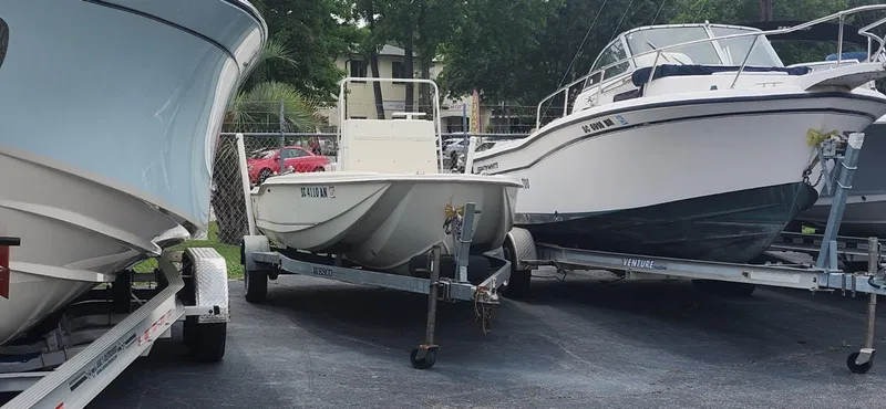 Slide: The Image of 1994 Scout 1720 CC Sportfish boat on trailer, parked among other boats. - 4