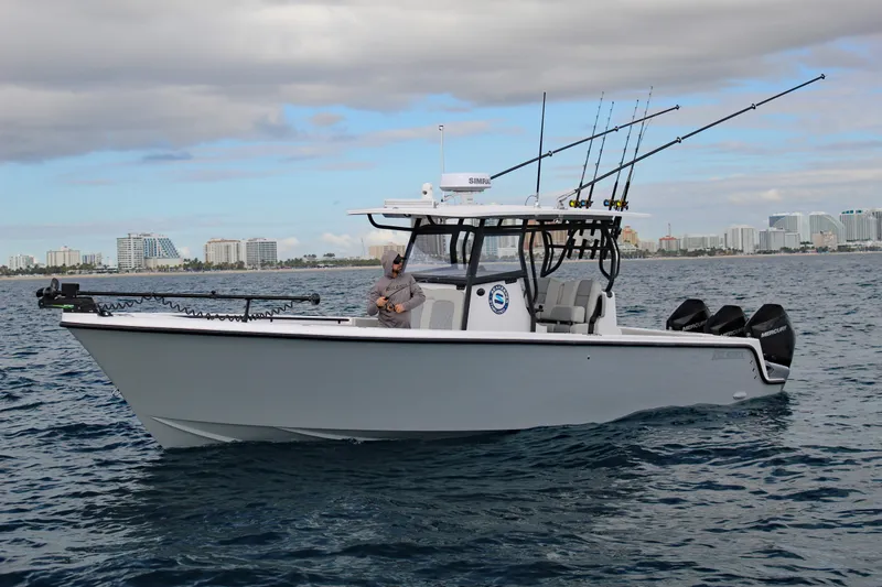 Slide: The Image of 2026 Reef Runner 340 boat on water, equipped with fishing rods and outboard motors. - 0