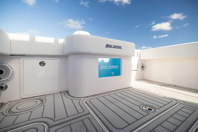 Slide: The Image of 2026 Reef Runner 340 boat deck with sleek design and modern features under a clear blue sky. - 14