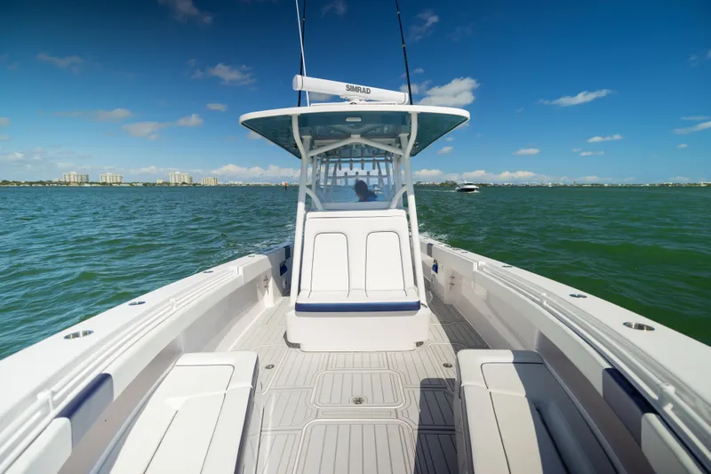 Slide: The Image of 2026 Reef Runner 340 boat cruising on open water under clear blue skies. - 16
