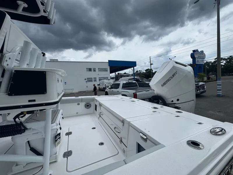 Slide: The Image of 2026 Blackfin 262 HB boat with Mercury engine, parked under cloudy skies. - 12