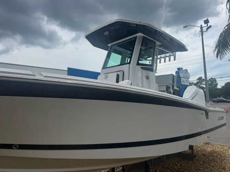 Slide: The Image of 2026 Blackfin 262 HB boat under cloudy sky, parked on gravel. - 13