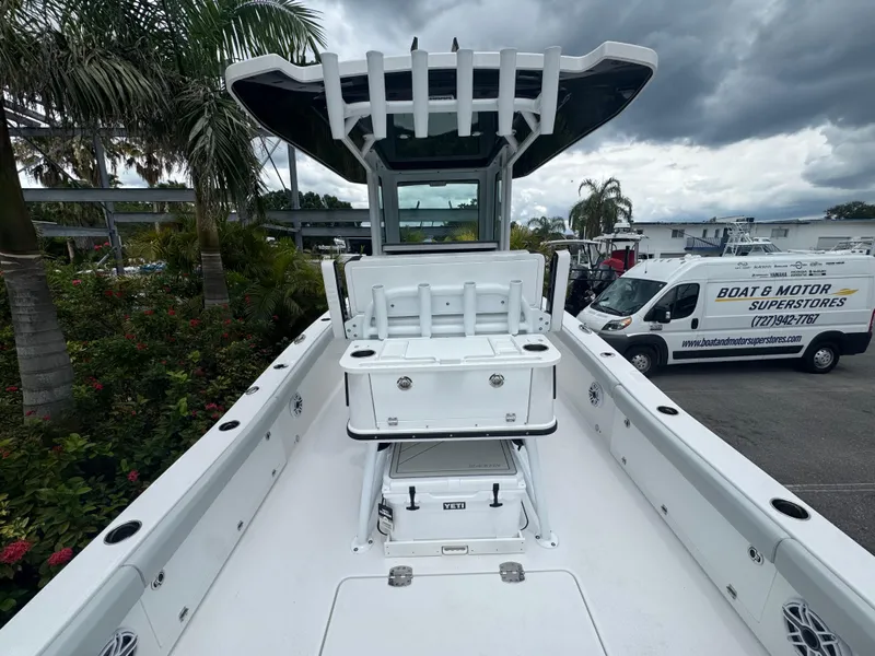 Slide: The Image of 2026 Blackfin 262 HB boat with center console, docked near palm trees and vehicles. - 18