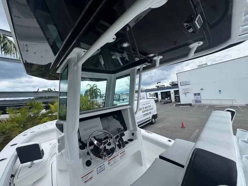 Slide: The Image of 2026 Blackfin 262 HB boat cockpit with Garmin navigation, docked near a white building. - 24