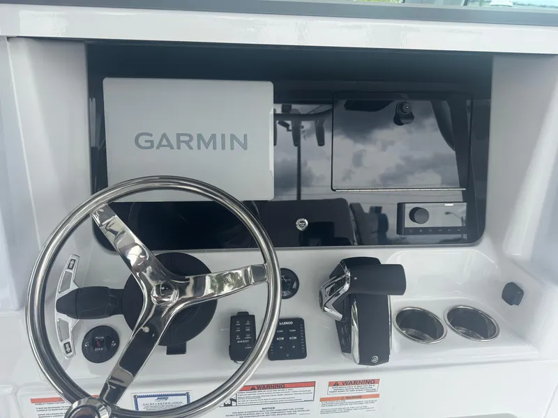Slide: The Image of Helm of 2026 Blackfin 262 HB boat with Garmin navigation system and steering wheel. - 26