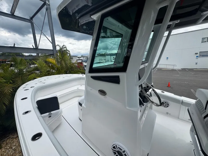 Slide: The Image of 2026 Blackfin 262 HB boat, sleek white design, modern helm, docked outdoors. - 28