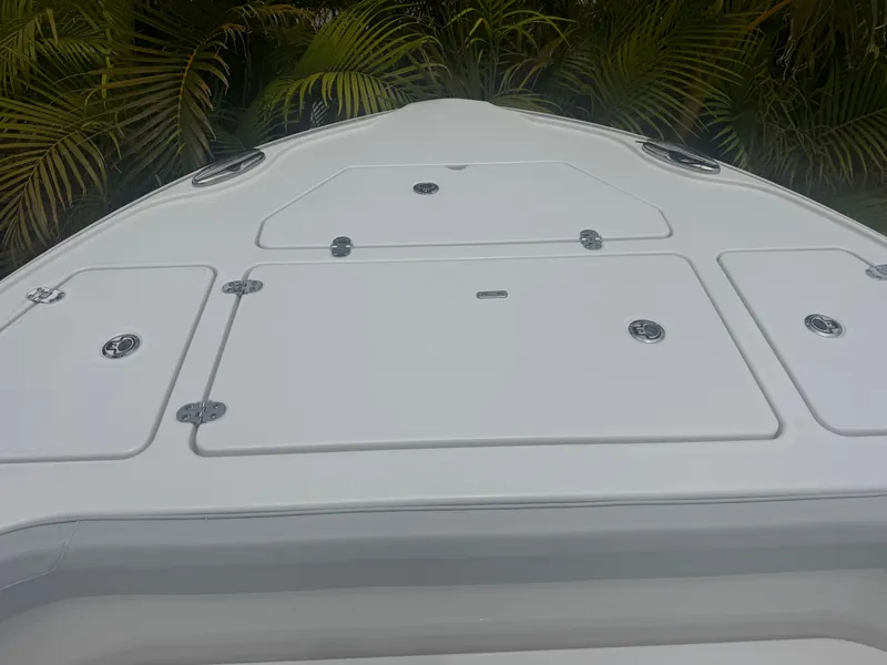 Slide: The Image of 2026 Blackfin 262 HB boat deck with storage hatches, surrounded by lush greenery. - 30