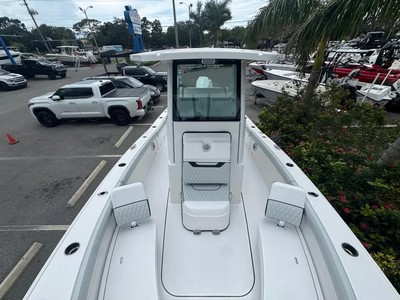 Slide: The Image of 2026 Blackfin 262 HB boat in parking lot, surrounded by vehicles and greenery. - 34