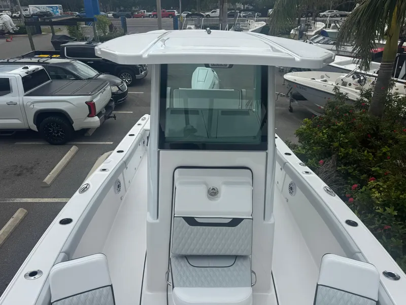 Slide: The Image of 2026 Blackfin 262 HB boat, sleek design, parked in marina with surrounding vehicles and greenery. - 35