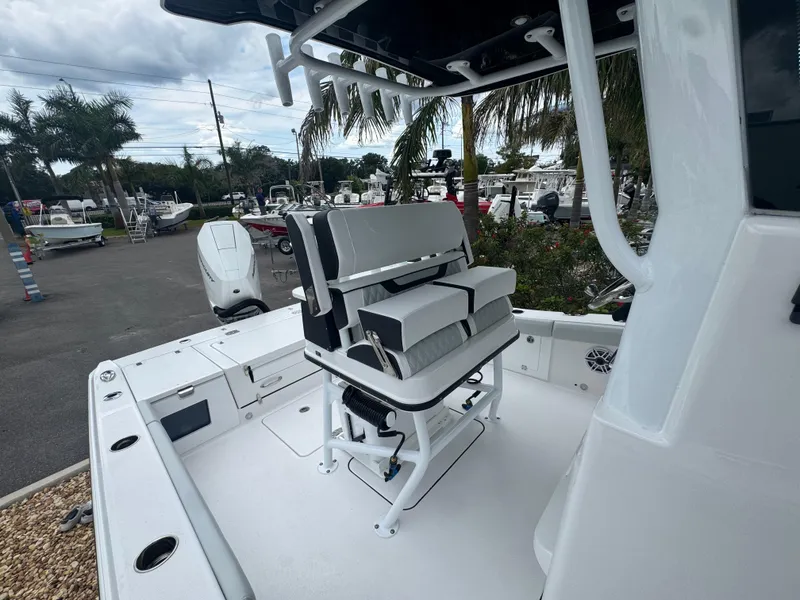 Slide: The Image of 2026 Blackfin 262 HB boat interior with seating, docked outdoors, surrounded by palm trees. - 43